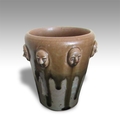 pot encircled with tiny sculpted heads