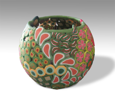 round vase covered in green themed polymer designs